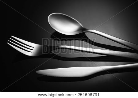 Set Of Stainless Steel Cutlery On A Black Reflective Background, Restaurant Concept