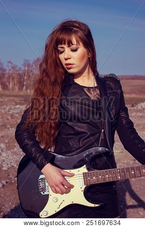 Beautiful Girl In Leather Jacket With Guitar