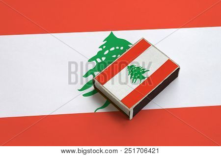 Lebanon Flag  Is Pictured On A Matchbox That Lies On A Large Flag.