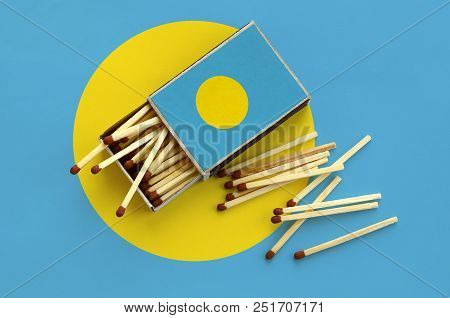 Palau Flag  Is Shown On An Open Matchbox, From Which Several Matches Fall And Lies On A Large Flag.