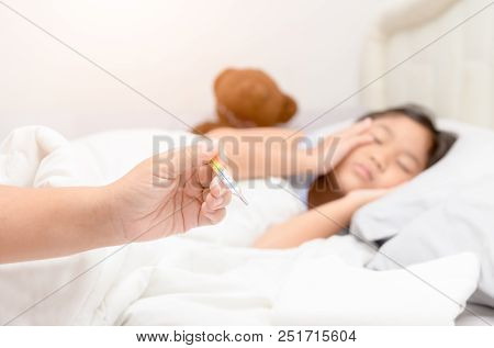 Mother Measuring Temperature Of Her Ill Kid From Thermometer.