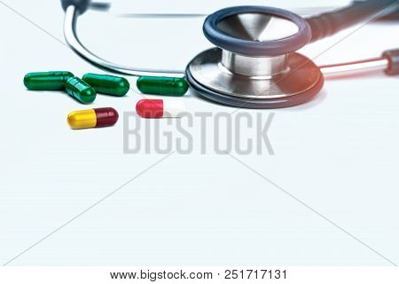 Green Stethoscope With Pile Of Antibiotic Capsule Pills On White Background. Antimicrobial Drug Resi