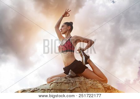 Yoga, Harmony Of Health, Woman Practicing Yoga On A Background Of Beautiful Dramatic Clouds With A B