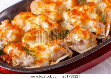 Fried Dumplings With Onion And Bacon On A Cast Iron Frying Pan. Molten Cheese.