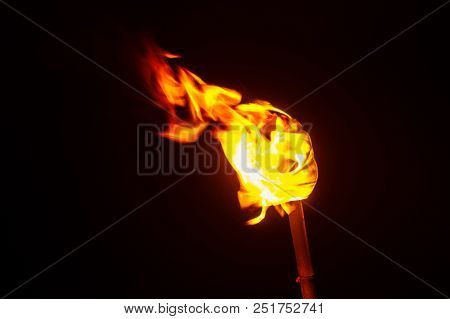 Torch Flame In The Darkness, Close Up Low Key Torch With Detail Of Burned Fabric.