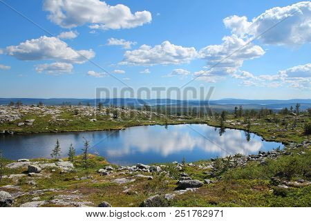 Small Pond Reflecting Blue Sky And White Clouds On Särkitunturi Fell Top In Muonio, Lapland, Finland