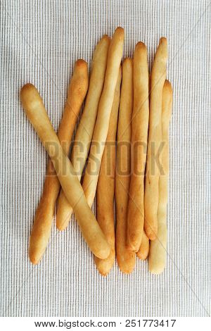 Tasty Dry Bread Italian Grissini On Light Fabric. Grissini Lies On Tablecloth. Vertical Format. Top 