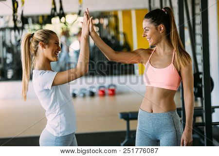 Fitness, Sport, Friendship And Lifestyle Concept - Beautiful Women Making High Five Gesture In Gym
