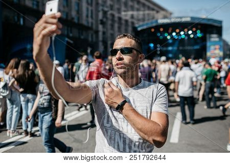 A Young Boy Is A Coverage Of A Sporting Event, Or A Concert. A Blogger Is Using A Smartphone To Go L