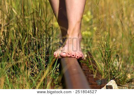 Women`s Bare Feet With Red Nails On Rails.woman Without Shoes With Red Nails Walking Along The Train