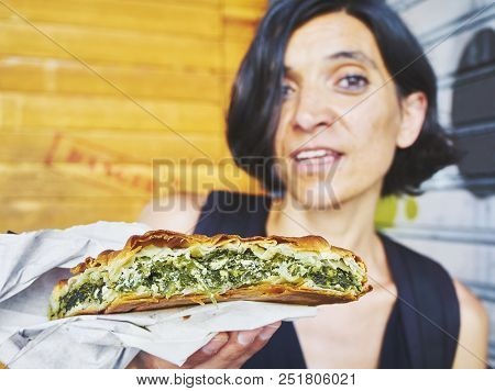 Greek Woman Eating A Traditional Spanakotiropita, Spinach And Feta Pie.