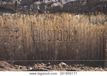 Texture Of Soil With Traces Of A Bucket Of Excavator. Wall Ground Of Section Quarry Pit For Foundati