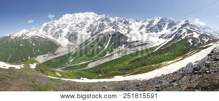 Svaneti Mountains Landscape In Georgia. Caucasian Ridge With Snowy Mountain Peaks And Green Grass On