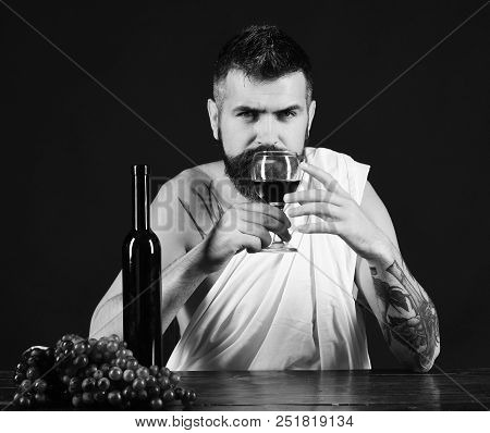 Winemaking And Degustation Concept. Sommelier Smells Drink. God Bacchus With Serious Face Wearing Wh