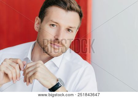 Image Of Thoughtful Self Confident Male Entrepreneur In White Shirt, Listens Attentively His Busines