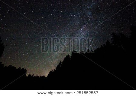 A View Of The Stars Of The Milky Way With A Mountain Top In The Foreground. Night Sky Nature Summer 