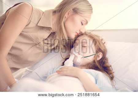 Sick Girl Lying On The Hospital Bed And Her Mom Kiss To Support.