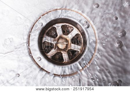 A Bright Dirty Drain Of A Kitchen Sink With Flowing Water, Top Down View