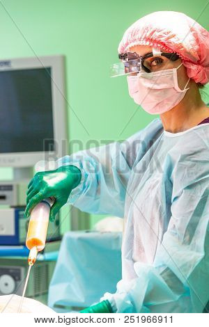 Cosmetic Liposuction Surgery In Actual Operating Room, Group Of Surgeons Working With Cannula