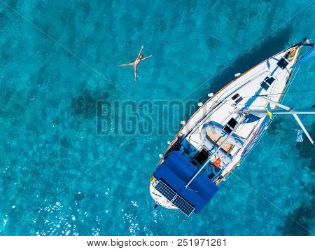 Amasing Aerial View To Yacht In Deep Blue Sea With Swimming Girl. Drone Photography