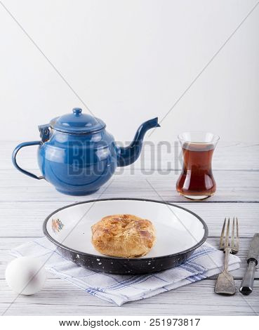 Turkish Borek Boyoz With Egg And Tea On Wooden Background
