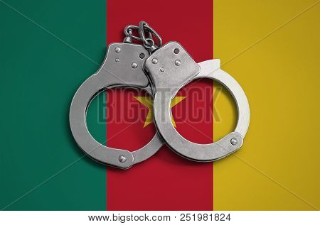 Cameroon Flag  And Police Handcuffs. The Concept Of Observance Of The Law In The Country And Protect