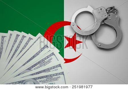 Algeria Flag  With Handcuffs And A Bundle Of Dollars. The Concept Of Illegal Banking Operations In U