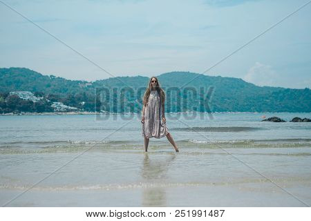 Handsome Girl On The Beach Background. Portrait Of A Woman In White Clothes On The Sea
