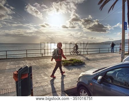 Woman Hiker With Backpack Walk Quickly  At Sea Via Pomenade  At Palma De Mallorca City, 26th Of Janu