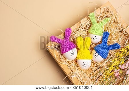Easter Background. Four Easter Decorative Eggs With Painted Cheerful Faces And Crocheted Ears In The