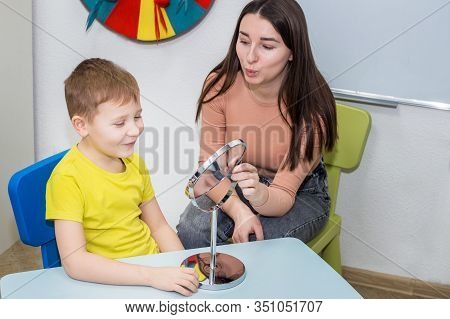 Speech Therapy. A Young Speech Therapist Is Engaged In Cubes With A Boy. Learning The