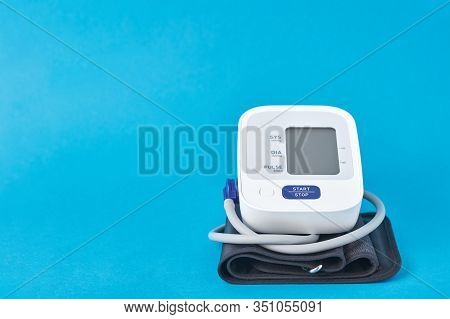 Digital Blood Pressure Monitor On A Blue Background, Closeup. Helathcare And Medicine Concept