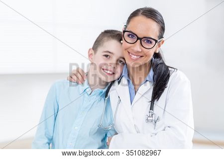 Happy Pediatrician Female Doctor And Young Boy In Ambulance. People And Pediatry Concept.