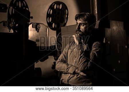 Beautiful Hipster Man Standing Near A Film Projector In The Room Projectionist