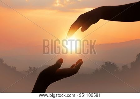 Giving A Helping Hand On The Background Of The Sunset.