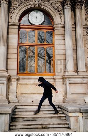 Teen In Glasses And Black Clothes Standing On The Steps Of An Old Building In Istanbul