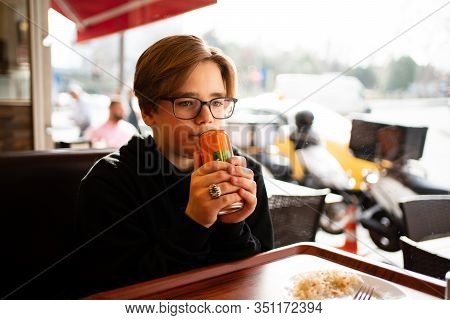 A Teenage Boy Drinks A Drink From A Can In A Cafe At A Window In Istanbul