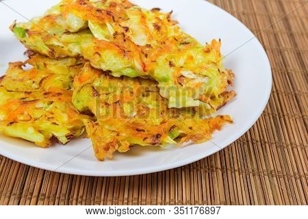 Fried Savory Cabbage Pancakes On White Dish On The Bamboo Table Mat, Fragment Close-up In Selective 