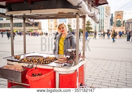 Blonde Girl On A Tray With Roasted Chestnuts On The Street In Istanbul