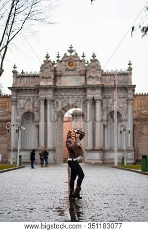 Beautiful Red-haired Girl On The Street In The Rain In Scarf