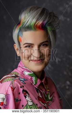 Portrait Of A Young Beautiful Girl In A Pink Shirt On A Gray Background With Dyed Hair. Short Haircu