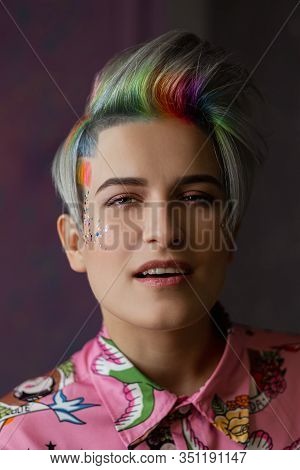 Portrait Of A Young Beautiful Girl In A Pink Shirt On A Gray Background With Dyed Hair. Short Haircu