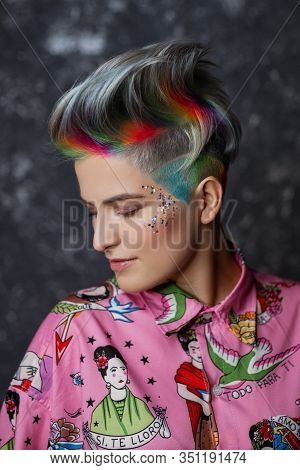 Portrait Of A Young Beautiful Girl In A Pink Shirt On A Gray Background With Dyed Hair. Short Haircu
