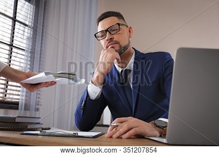 Woman Offering Bribe To Man At Table In Office