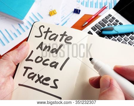 Man Calculating State And Local Taxes In The Note.