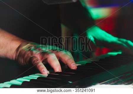 Hands Of A Pianist Or Keyboardist Of A Rock Band Close Up Playing A Synthesizer. Selective Focus