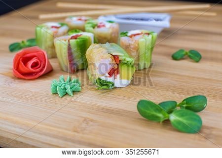 Japanese Sushi Food On A Wooden Board. Salmon, Rice, Wasabi, Ginger, Chopsticks Hashi Japanese Cuisi