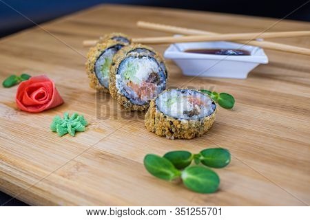 Japanese Sushi Food On A Wooden Board. Salmon, Rice, Wasabi, Ginger, Chopsticks Hashi Japanese Cuisi