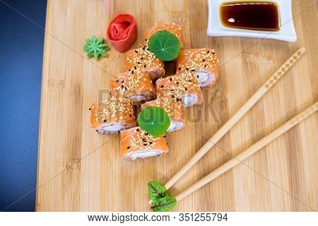 Japanese Sushi Food On A Wooden Board. Salmon, Rice, Wasabi, Ginger, Chopsticks Hashi Japanese Cuisi