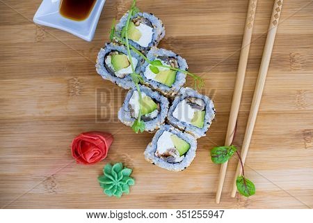 Japanese Sushi Food On A Wooden Board. Salmon, Rice, Wasabi, Ginger, Chopsticks Hashi Japanese Cuisi